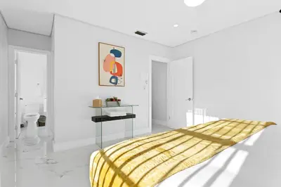 a bedroom with white walls and a bed with a yellow blanket at Cozy 4BR Pool Villa Near The Beach with Arcades in Fort Lauderdale