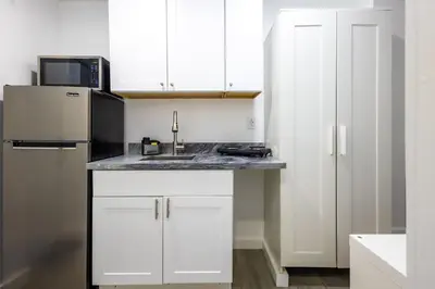a white kitchen with a sink and a refrigerator at The Side Villa in Miami