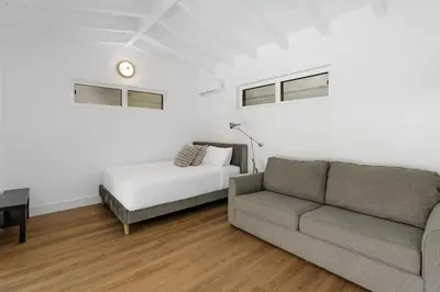 a living room with a couch and a bed at Memory Lane Cozy Home with Pool Lush South Miami in Miami