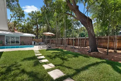 a backyard with a tree and a fence at Memory Lane Cozy Home with Pool Lush South Miami in Miami