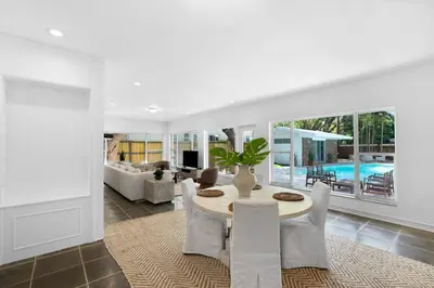 a dining room with a table and a living room at Memory Lane Cozy Home with Pool Lush South Miami in Miami
