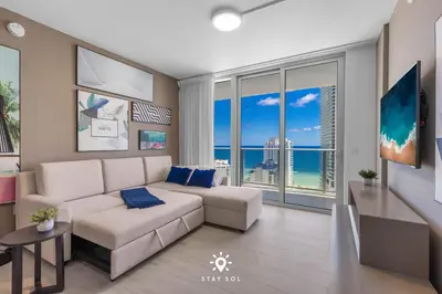 a living room with a white couch and a view of the ocean at Luxury 2BR Apt With Ocean View Pool & Amenities in Hollywood
