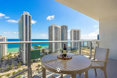 a table and chairs on a balcony with a view of the ocean at Luxury 2BR Apt With Ocean View Pool & Amenities in Hollywood