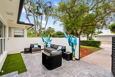 a patio with two couches and chairs in a yard at Beach Pop - Steps to Beach Heated Pool & Hot Tub in Fort Lauderdale