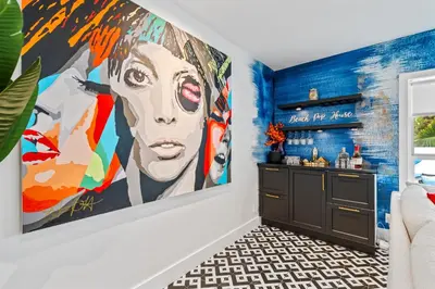 a room with a large painting of a woman on the wall at Beach Pop - Steps to Beach Heated Pool & Hot Tub in Fort Lauderdale