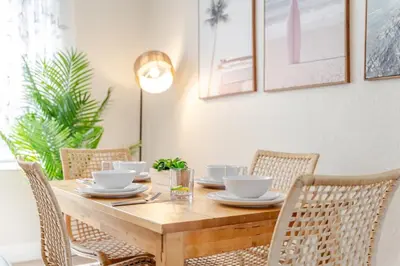 a dining room table with chairs and a wooden table with bowls at Oceanfront Bliss Cozy 1BR by Beach Free Parking in Hollywood