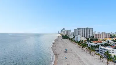 an aerial view of a beach with palm trees and buildings at Oceanfront Bliss Cozy 1BR by Beach Free Parking in Hollywood