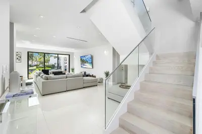 a white living room with a staircase and a couch at Villa Costa in Hollywood