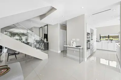 a white kitchen with a staircase and a dining room at Villa Costa in Hollywood