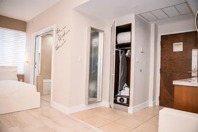 a bedroom with a walk in closet with a mirror at Cozy Studio Ocean Drive - Roof Top Pool with Bar in Miami Beach