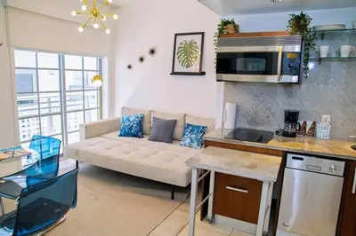 a living room with a couch and a kitchen at Miami Ocean Drive 1BR APT & Rooftop Pool Access in Miami Beach
