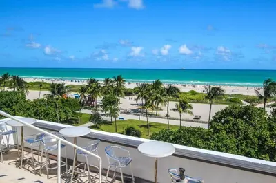 a balcony with chairs and a view of the beach at Miami Ocean Drive 1BR APT & Rooftop Pool Access in Miami Beach