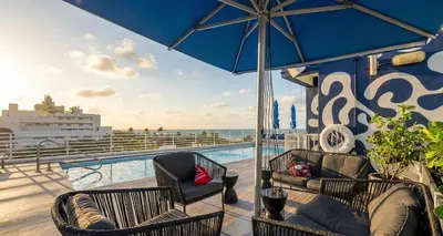 a balcony with two chairs and an umbrella on a cruise ship at The iconic Ocean Drive - 1 BDR - Rooftop Pool and Bar in Miami Beach
