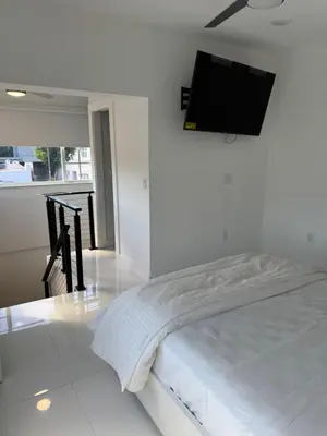 a bedroom with a bed with a tv on the wall at In the heart of little Havana 5 in Miami