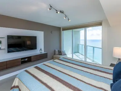 a bedroom with a large bed and a large window at Lovely 2-Bedroom Oceanfront condo in Sunny Isles Beach
