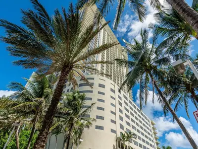 a tall building with palm trees in front of it at Lovely 2-Bedroom Oceanfront condo in Sunny Isles Beach