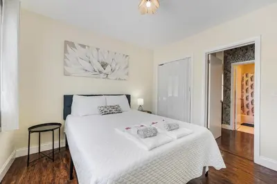 a white bedroom with a large bed with white sheets at Cozy 1BR Apt Steps from Calle 8 & Mins to Brickell in Miami