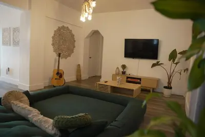 a living room with a green couch and a television at Near Brickell, Beach & Port 10min, Style & Comfort in Miami