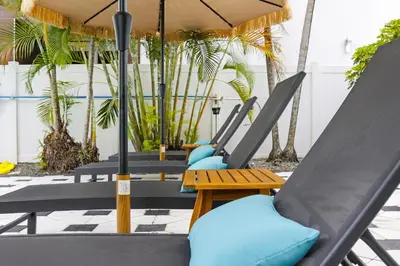 a row of chairs with umbrellas on a patio at The Victoria Hotel in Fort Lauderdale