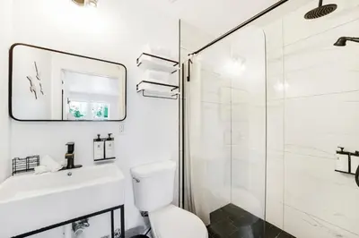 a bathroom with a shower and a toilet and a sink at The Victoria Hotel in Fort Lauderdale