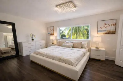 a white bedroom with a large bed and a window at Villa Miami Lakes 2 in Hialeah