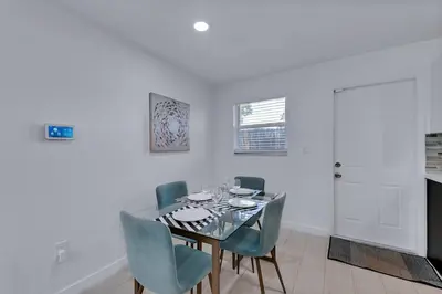 a dining room with a glass table and blue chairs at Modern 2BR Near Wynwood and Design District in Miami