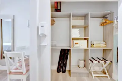 a room with a white closet with shelves and a chair at Sunny Beach Studio Steps to Ocean and Nightlife in Miami Beach