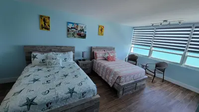 a bedroom with a bed and a bed and a window at Amazing ocean view studio 14 floor Free parking in Miami Beach