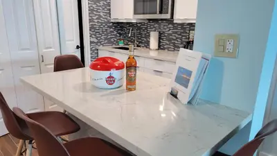 a kitchen table with a bottle of beer and a computer on it at Amazing ocean view studio 14 floor Free parking in Miami Beach