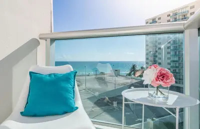 a vase of flowers sitting on a table on a balcony at Hollywood Beachfront 2-Bedroom Condo with Ocean Views in Hollywood