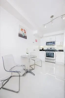 a white kitchen with a table and chairs at Hollywood Beachfront 2-Bedroom Condo with Ocean Views in Hollywood