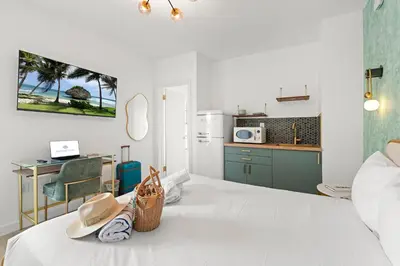 a room with a bed with a kitchen and a table at The Bianco in Miami