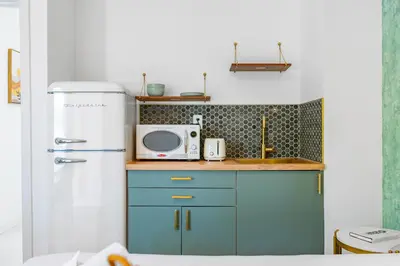 a small kitchen with a microwave and a refrigerator at The Bianco in Miami