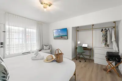 a white bedroom with a bed and a desk at The Bianco in Miami