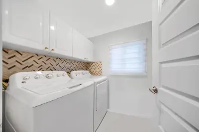 a white laundry room with a washer and dryer at Waterfront 2BR Unit with Bayview Boho Style Stunning Sunset Pool Hot Tub Gym in Sunny Isles Beach