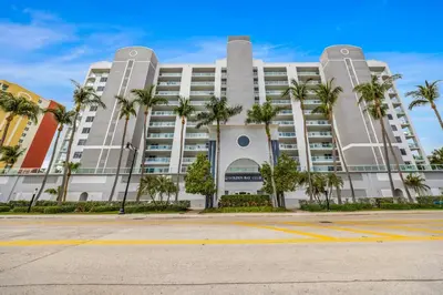 a large white building with palm trees in front of it at Waterfront 2BR Unit with Bayview Boho Style Stunning Sunset Pool Hot Tub Gym in Sunny Isles Beach