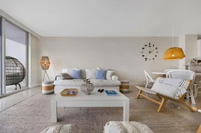 a living room with a white couch and a table at Waterfront 2BR Unit with Bayview Boho Style Stunning Sunset Pool Hot Tub Gym in Sunny Isles Beach