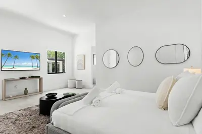 a white room with a bed and a couch and mirrors at Villa Coral Wave in Miami