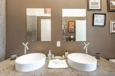 a bathroom with two white sinks on a counter at Beautiful Icon Brickell Double height ceiling in Miami