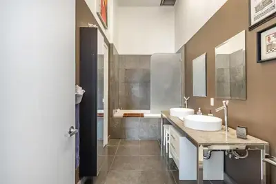 a large bathroom with two sinks and a shower at Beautiful Icon Brickell Double height ceiling in Miami
