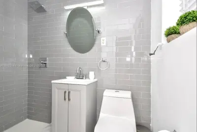 a bathroom with a toilet and a sink and a mirror at North Beach-Room with Private Entrance in Miami Beach