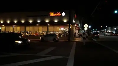 a man walking in front of a store at night at North Beach-Room with Private Entrance in Miami Beach