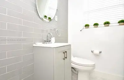 a white bathroom with a toilet and a mirror at North Beach-Room with Private Entrance in Miami Beach