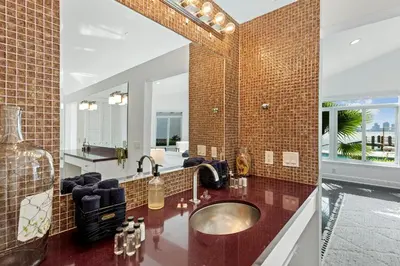 a bathroom with a sink and a mirror at Villa Tropique in Miami Beach