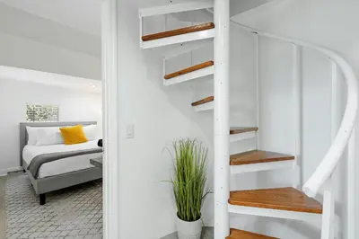 a white staircase in a bedroom with a bed at Villa Tropique in Miami Beach