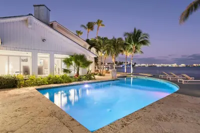 a large blue swimming pool next to a house at Villa Tropique in Miami Beach