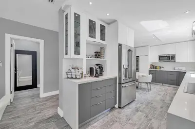 a kitchen with white cabinets and a refrigerator at Miami Sombra - Prime Location-Parkfront- Den-Gazebo in Miami