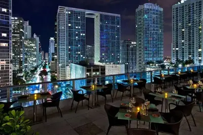 a restaurant with tables and chairs on a balcony with a city skyline at Stylish Brickell Condo with Balcony and Parking in Miami