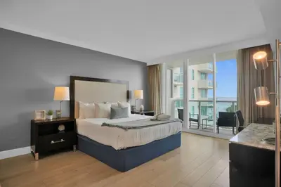 a bedroom with a large bed and a balcony at Modern Comfort Steps from the Ocean Breeze in Miami