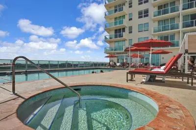 a pool with a hot tub next to a building at Modern Comfort Steps from the Ocean Breeze in Miami